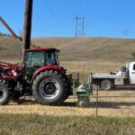 Merjent flatbed truck and tractor on electric transmission line right of way restoration project site.