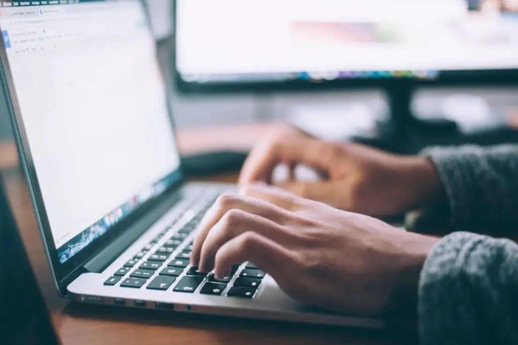 Person typing on a keyboard of a laptop.