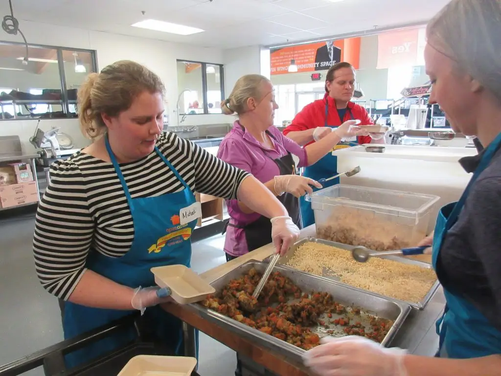 Merjent team members volunteering to make and pack meals for Open Arms of Minnesota. Food to be donated to people battling chronic and terminal illness. Company sponsored volunteer event with paid volunteer time. Michaela Swanson, Kim Jessen, Rob Jones, and Melissa Dellwo, in photo from left to right.